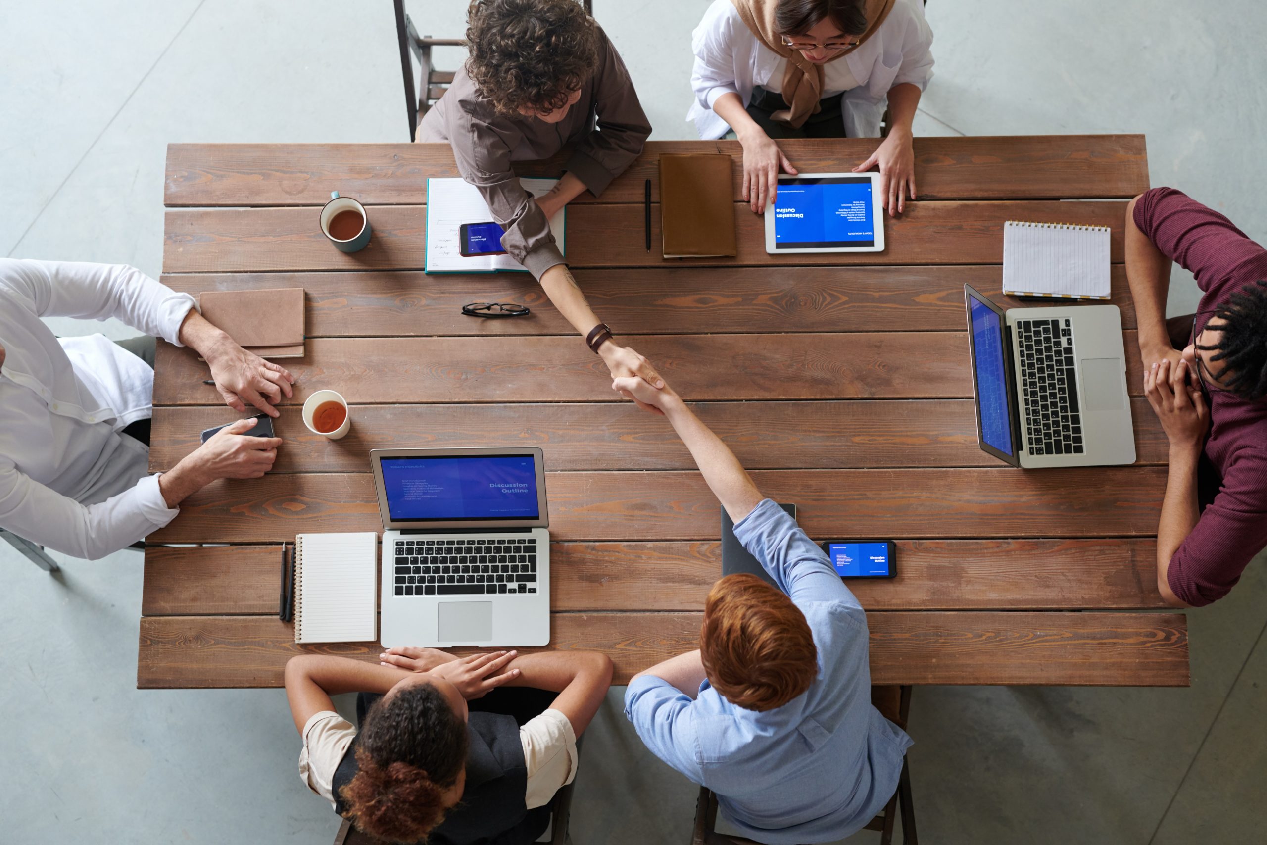 People shaking hands across a large table
