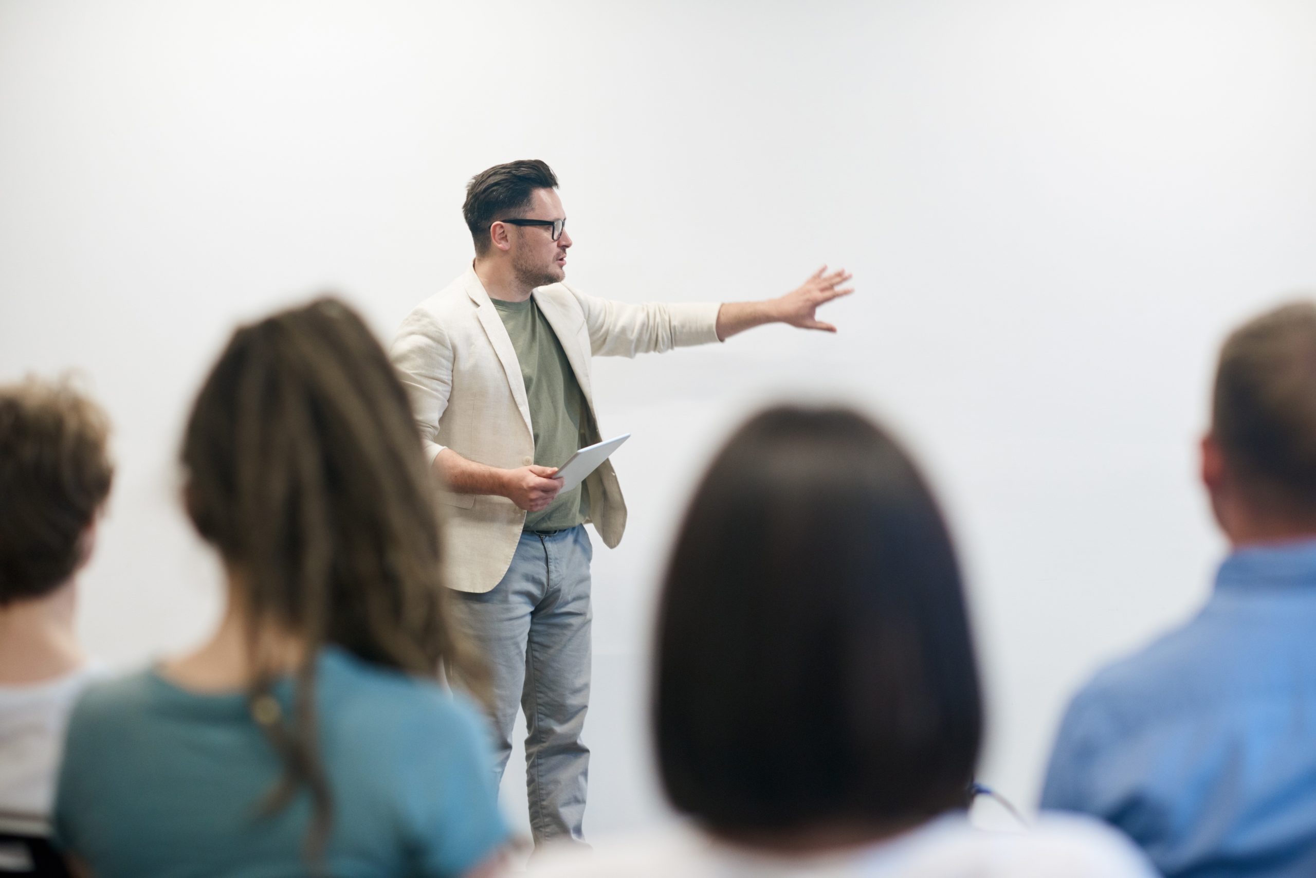 man stood in front of audience giving a talk