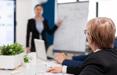 Woman sat at table looking at a flipchart