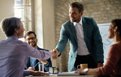 business coworkers shaking hands during a meeting in the office focus is on a businessman